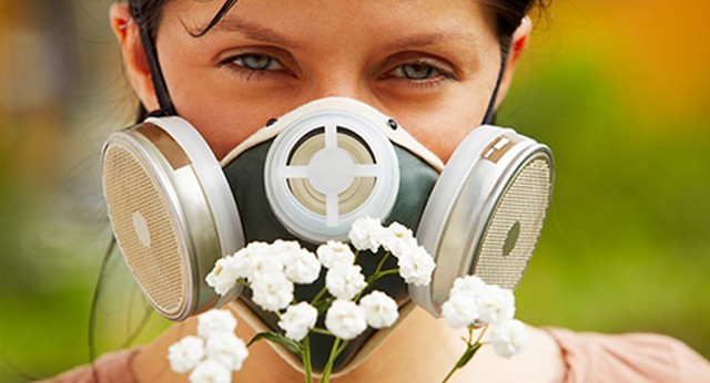 caucasian woman is wearing a gas mask